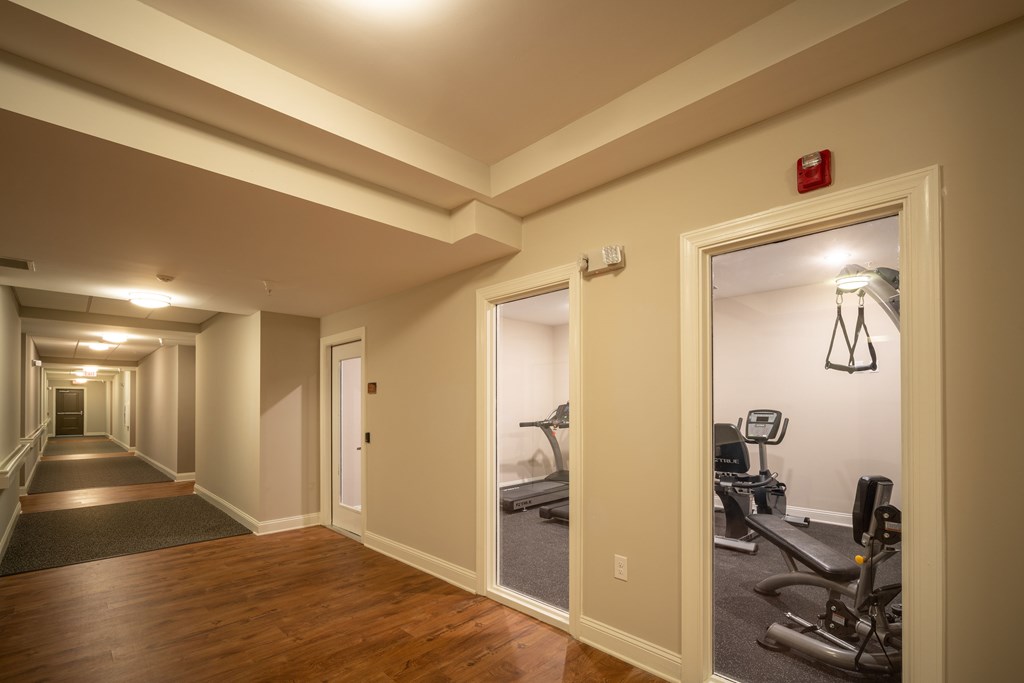 A hallway with a gym in the background.