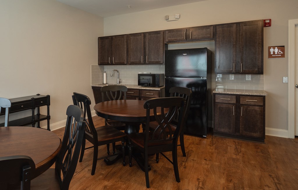 A kitchen with a table and chairs.