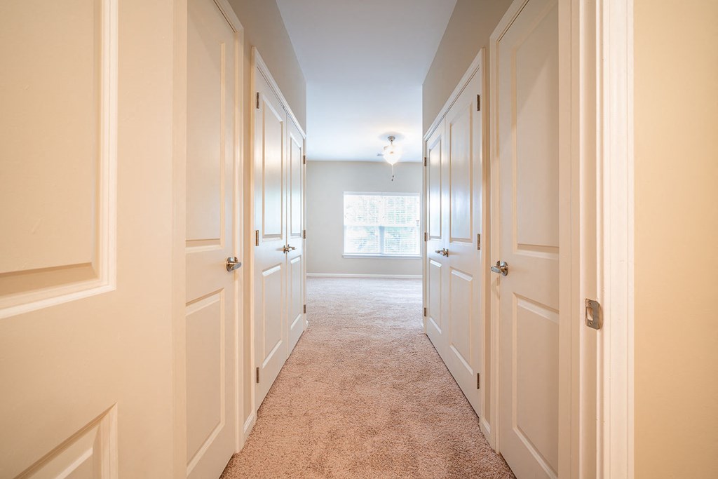 A long hallway with white doors on both sides.