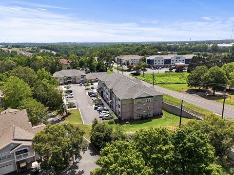 A large building surrounded by trees and a parking lot.