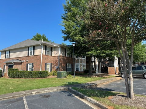 a large brick apartment building with a tree in front of it