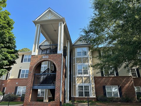 an apartment building with a red brick facade and a balcony