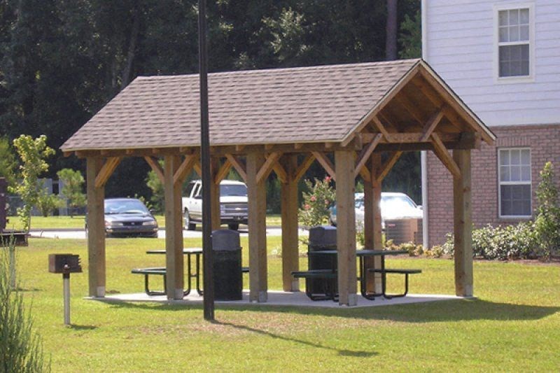 a man sitting on a picnic table in a pavilion