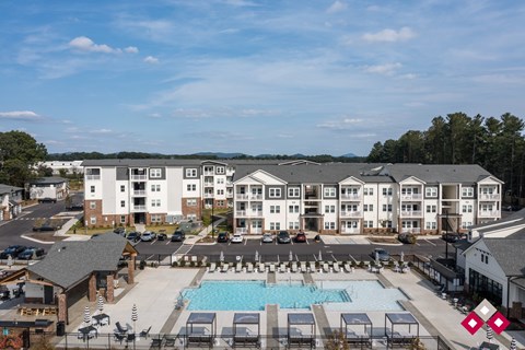 A large apartment complex with a pool in the foreground.