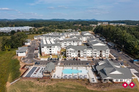 an aerial view of a resort with buildings and a pool