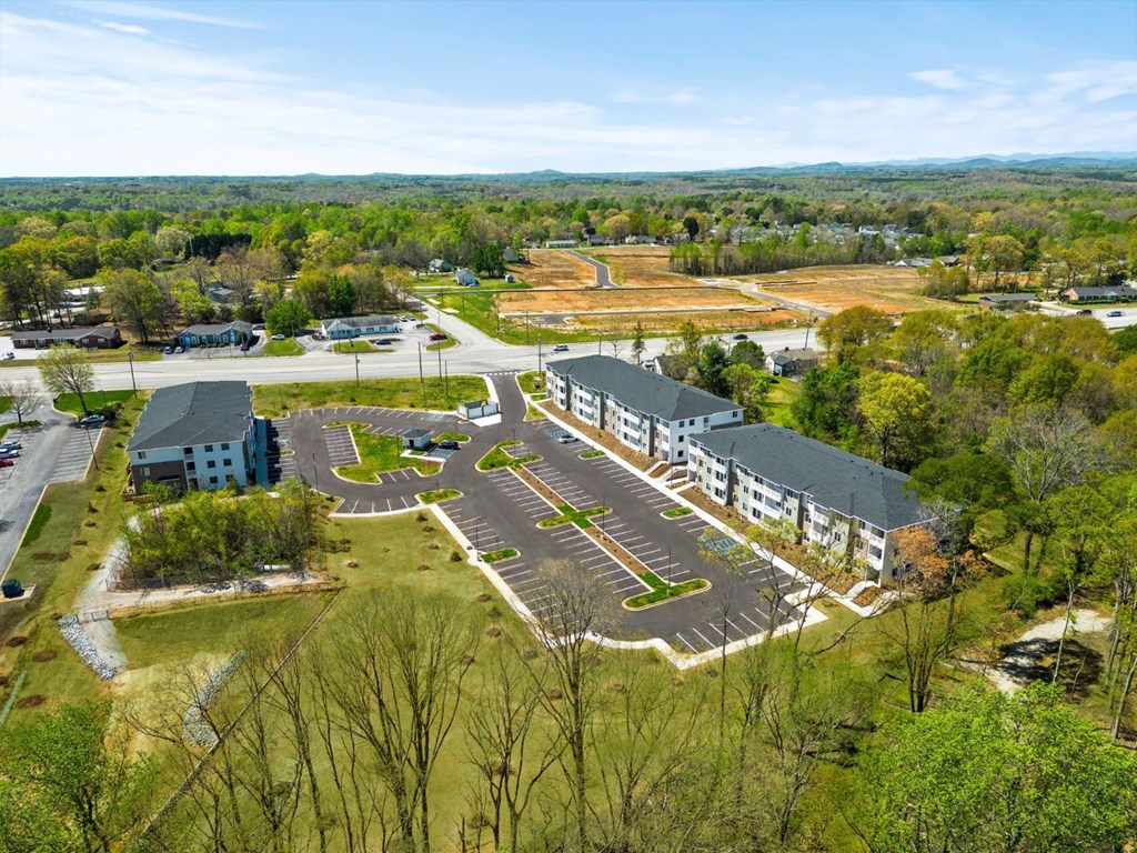 Dog-Friendly Apartments in Greenville SC - Alston - Overhead Exterior Shot of the Multiple Property Buildings and Parking Lot Surrounded by Lush Greenery