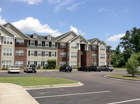 Apartment building with cars parked in front.