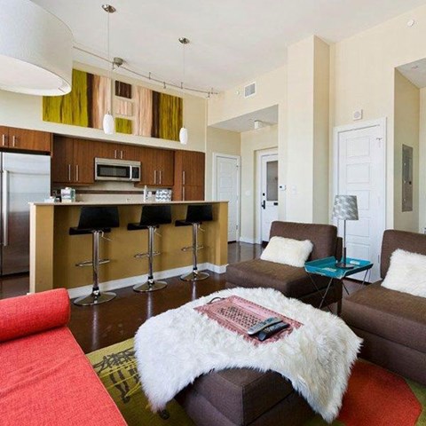 A living room with a white fur throw on a brown couch.