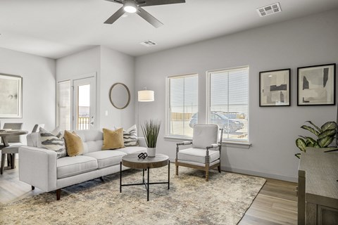 A living room with a white couch, a coffee table, and a ceiling fan.