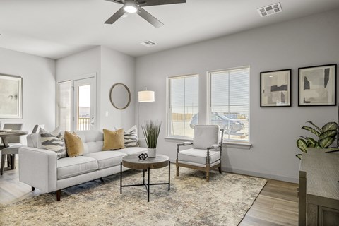 A living room with a white couch, a coffee table, and a ceiling fan.