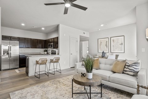 A modern kitchen with a bar area and a living room.