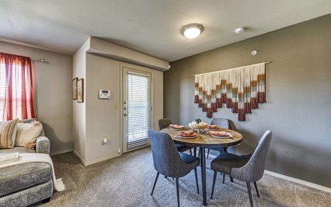 A dining room with a grey table and chairs.