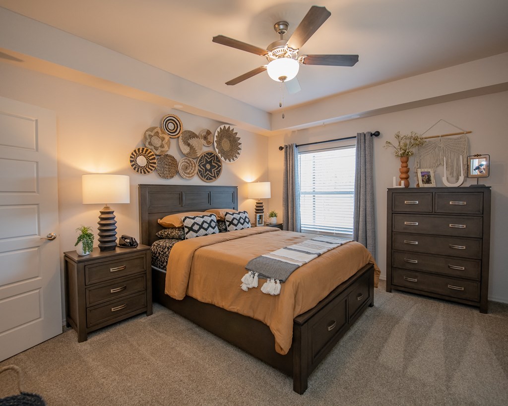 A bedroom with a bed, nightstand, and dresser.