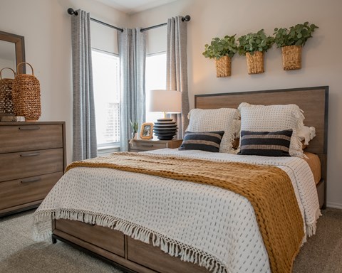 A bedroom with a large bed and a wooden dresser.