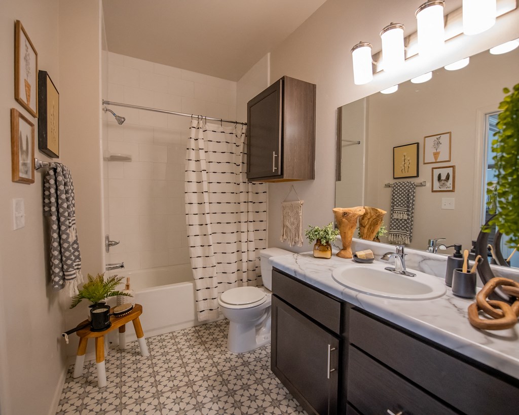 A bathroom with a white toilet, a sink, and a shower.
