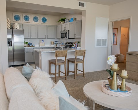 A modern kitchen with a white countertop and a refrigerator.