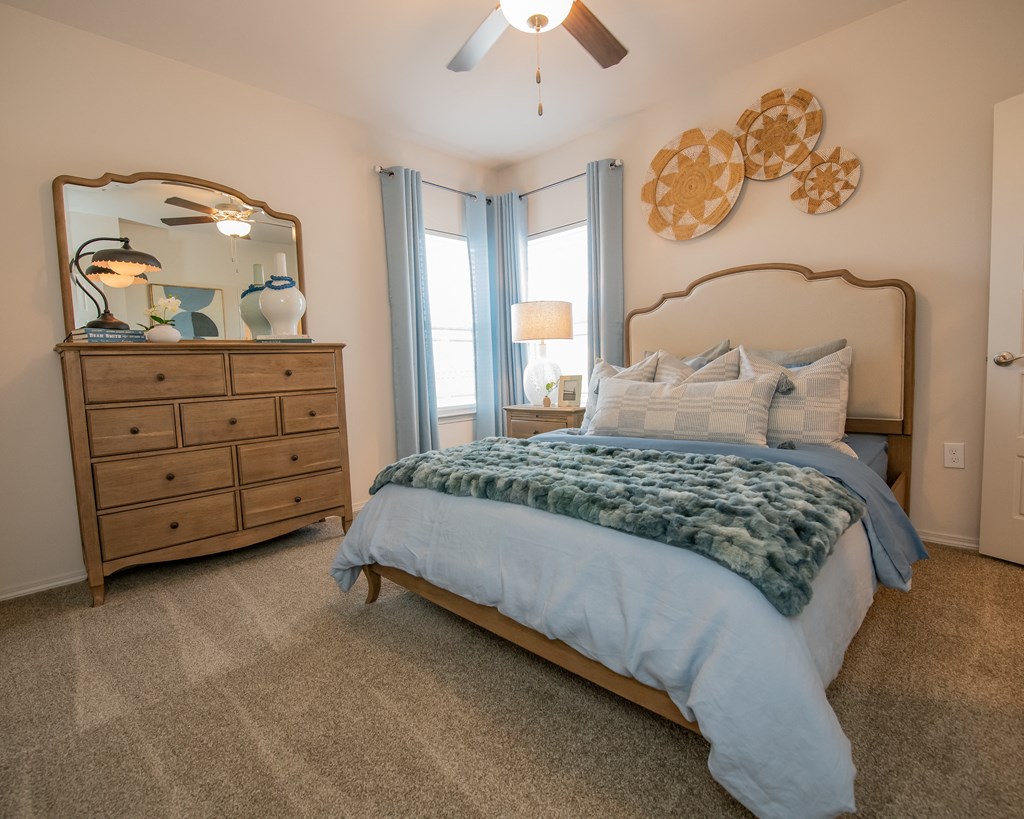 A bedroom with a bed, dresser, and mirror.