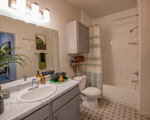 A white toilet is in a bathroom with a white sink.