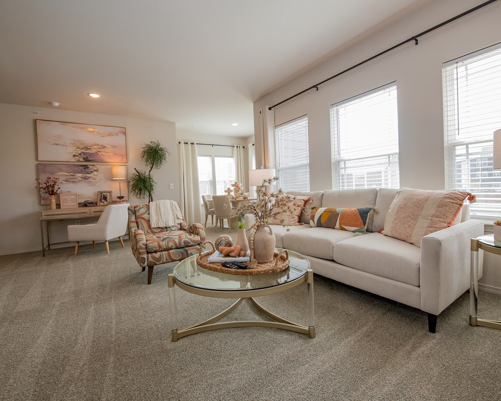 A living room with a white couch, a coffee table, and a painting on the wall.