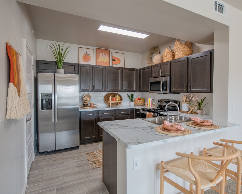 A kitchen with a refrigerator, microwave, and oven.