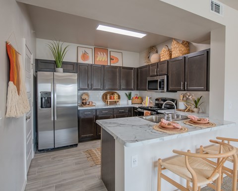 A kitchen with a refrigerator, microwave, and oven.