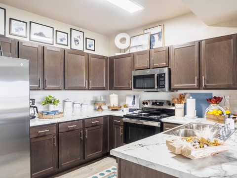 A kitchen with brown cabinets and a white counter.