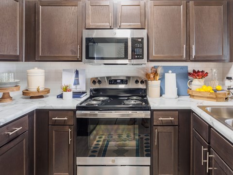 A modern kitchen with a stove top oven and microwave above it.
