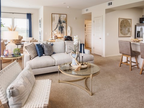 A living room with a white sofa and a glass coffee table.