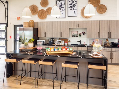A kitchen with a black countertop and stools.
