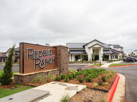 A sign that says Redbud Ranch in front of a building.