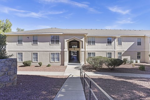 A building with a grey roof and a stone pillar on the left.