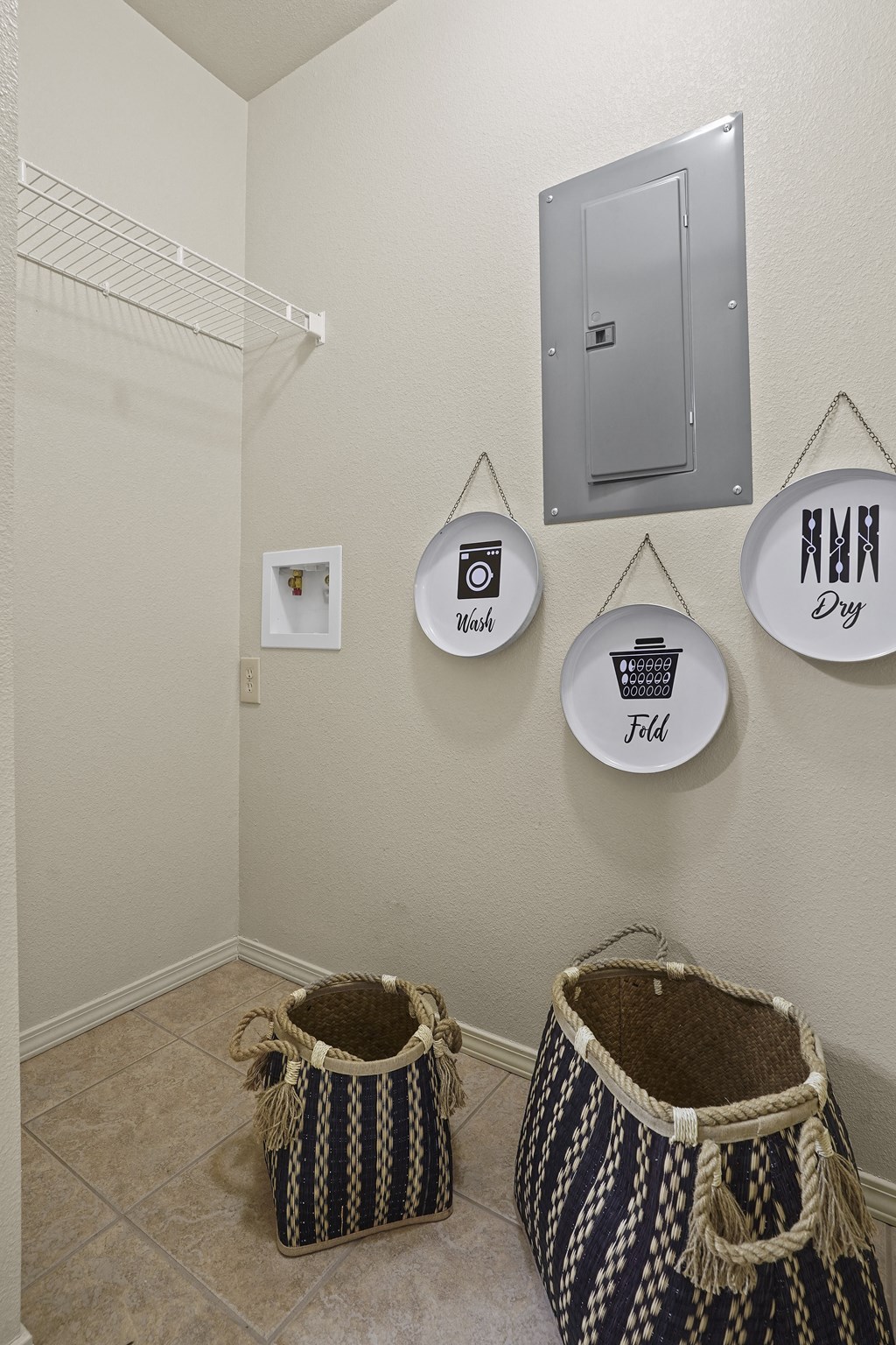 A bathroom with a towel rack and two baskets on the floor.