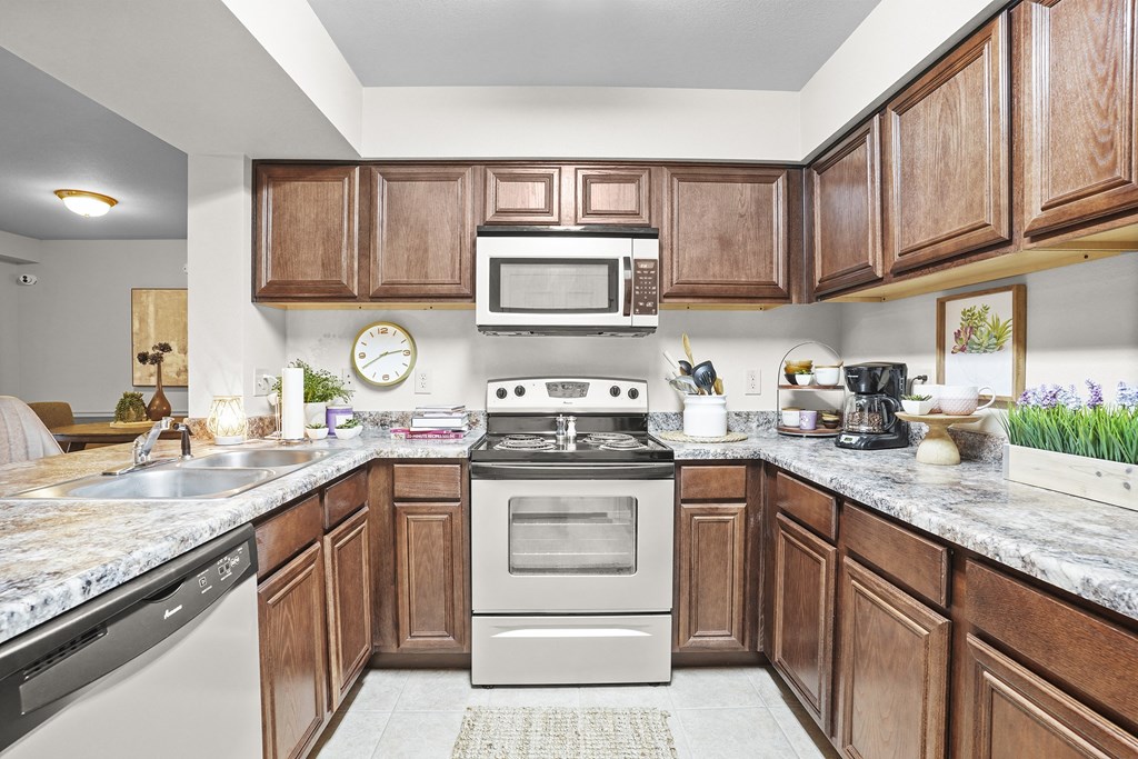 A kitchen with wooden cabinets and a granite countertop.