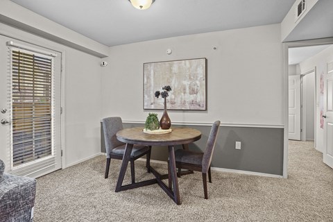A dining room with a table and chairs.