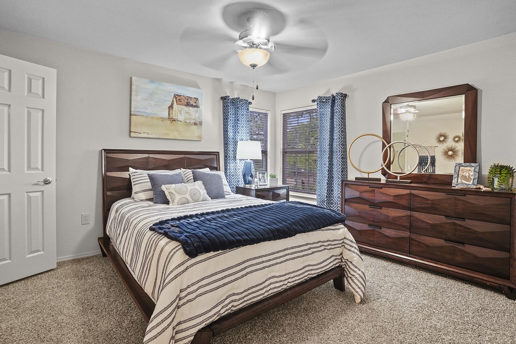 A bedroom with a bed, dresser, and mirror.