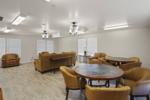 A room with a table surrounded by chairs.