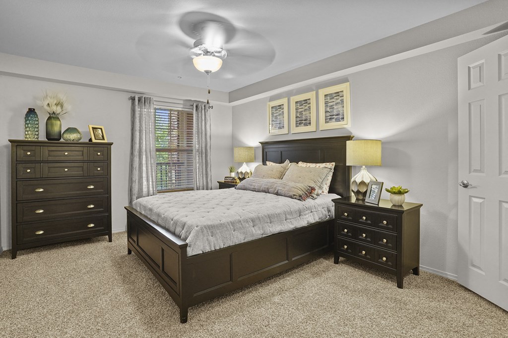 A bedroom with a bed, dresser, and nightstand.