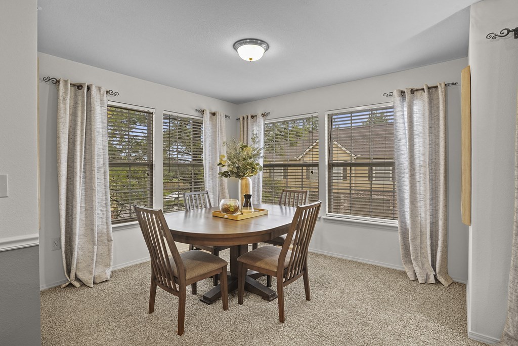 A dining room with a round table and chairs.