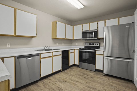 A kitchen with white cabinets and stainless steel appliances.