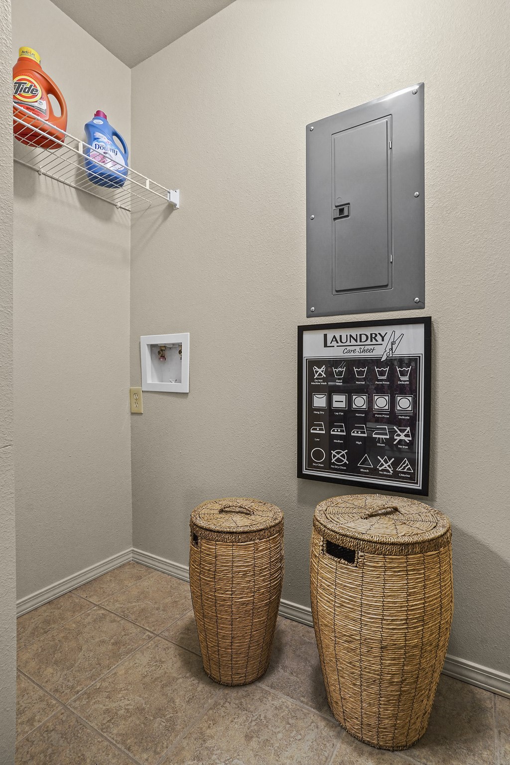 Laundry room with a washer and dryer, a sign with symbols, and two wicker baskets.
