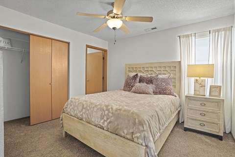 A bedroom with a bed, dresser, and closet.