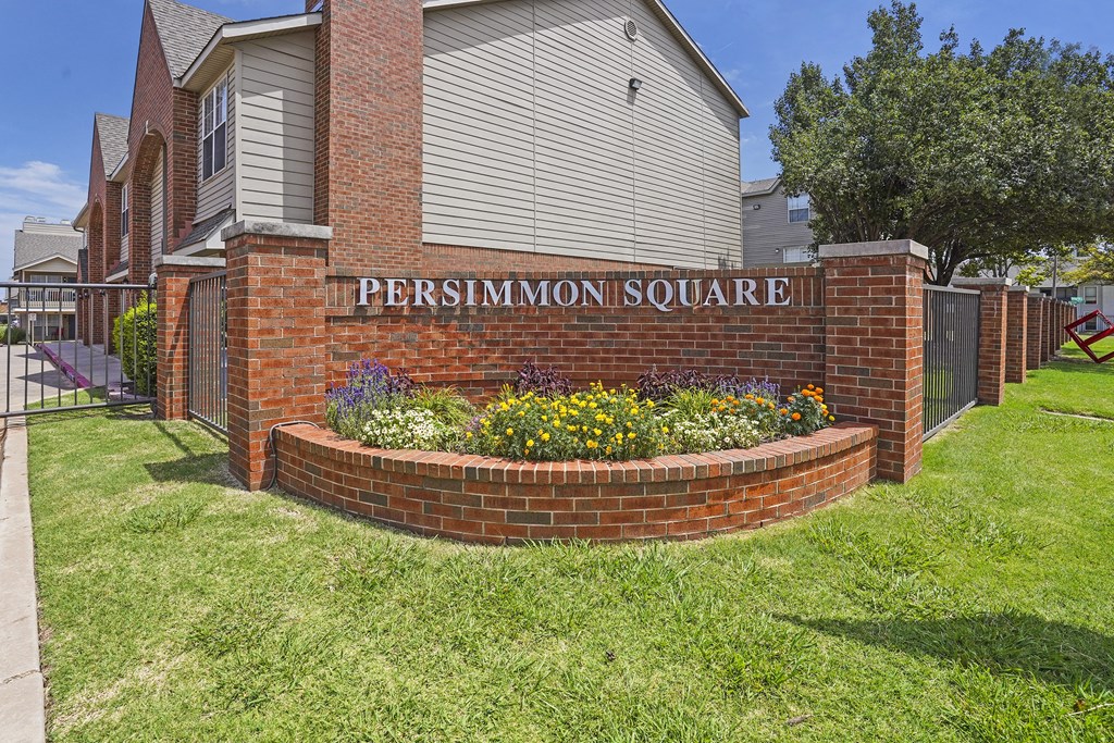 A brick wall with Persimmon Square written on it.