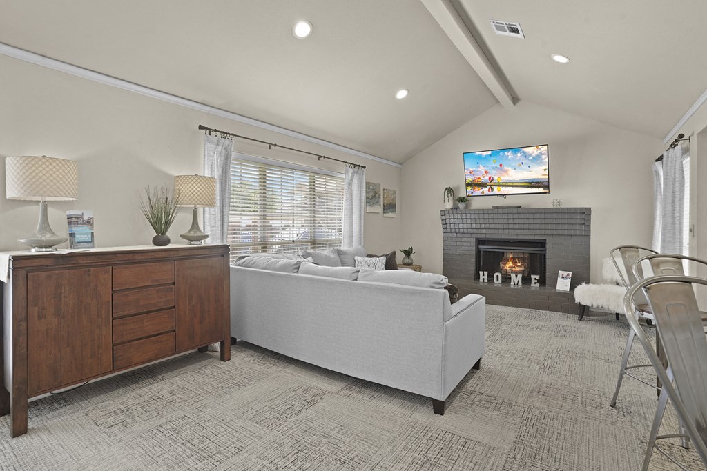 A modern bedroom with a fireplace and a television.