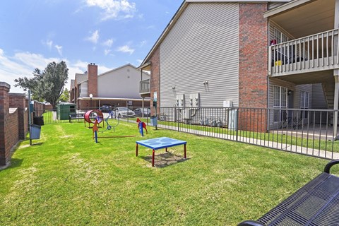 A playground with a blue table and a red swing set.
