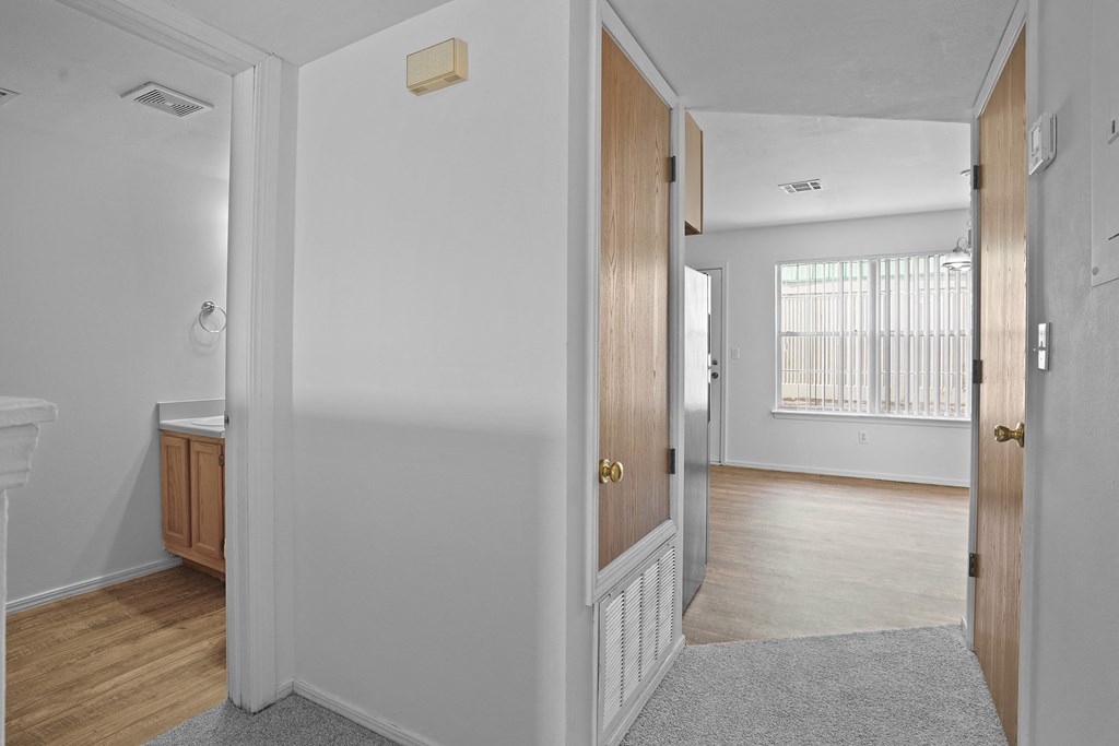 A hallway with a white door and a brown door.