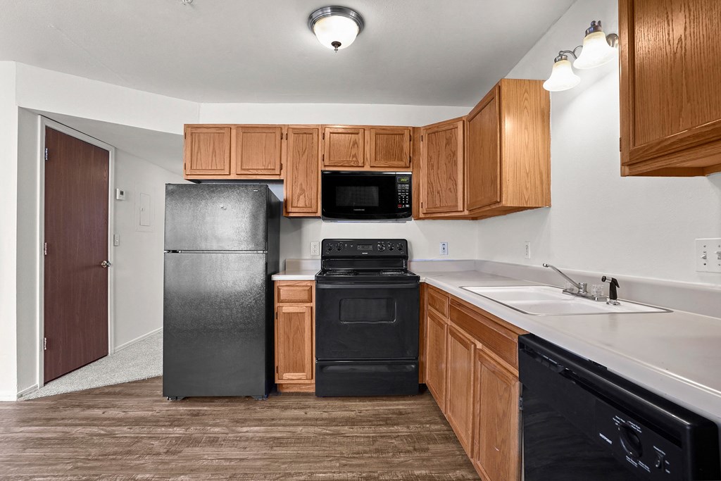 A kitchen with black appliances and wooden cabinets.