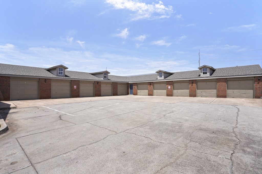 A parking lot in front of a building with a clear blue sky.