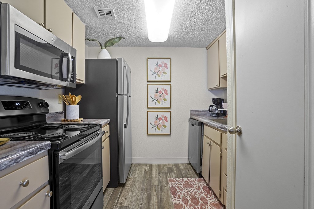 A kitchen with a black stove top oven and a black refrigerator.