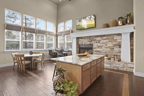 A living room with a stone fireplace and a television mounted above it.
