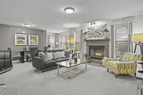 A living room with a grey carpet and a fireplace.